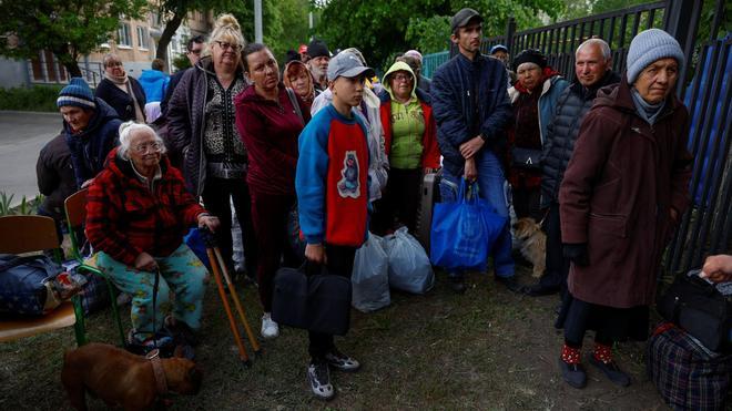 Residentes de Vovchansk, en el norte de Járkov, esperan en un punto de concentración tras ser evacuados de sus hogares REUTERS/Valentyn Ogirenko