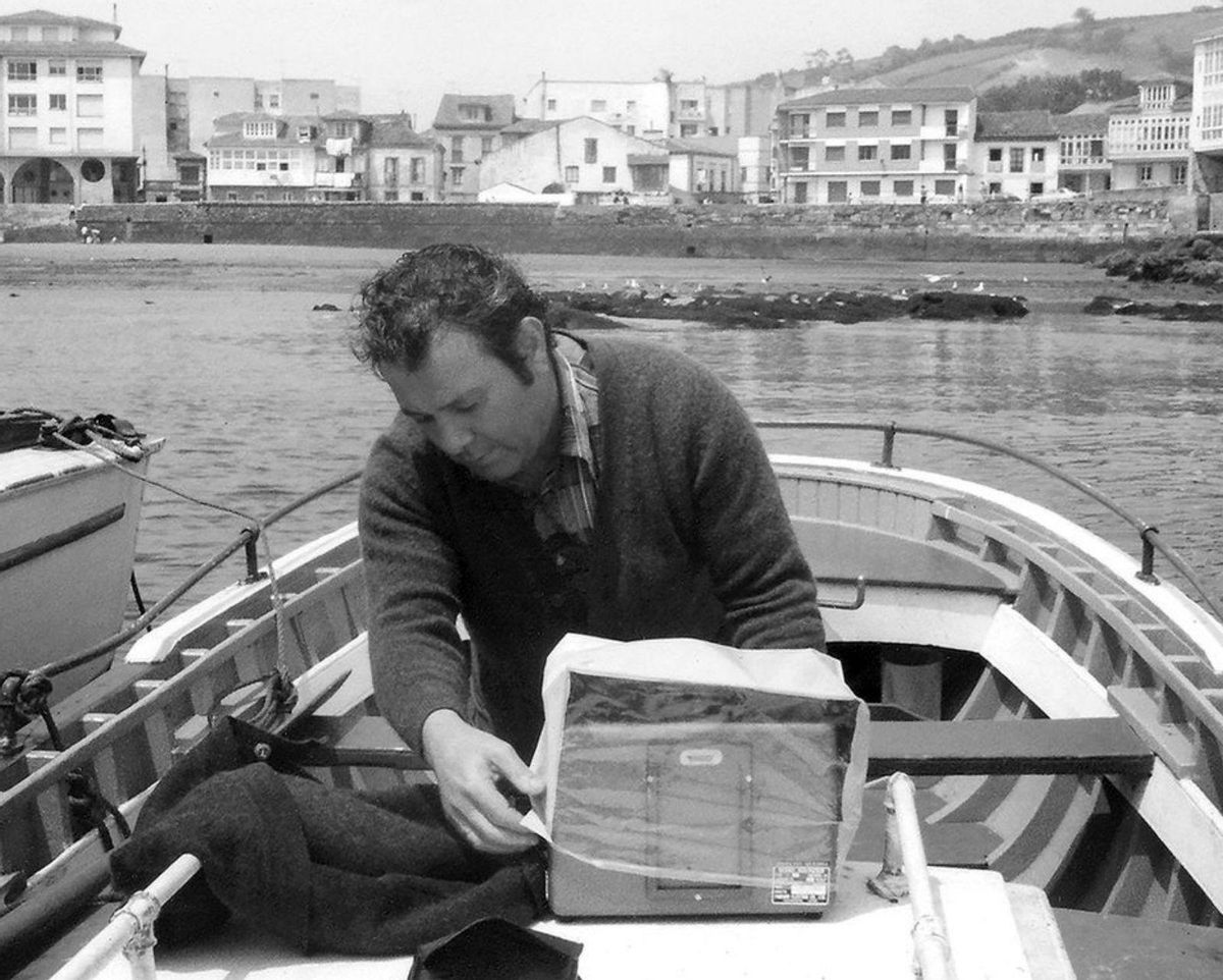 José Andrés Menéndez, autor de las fotografías, en su lancha, La Romaniella, amarrada en el muelle.