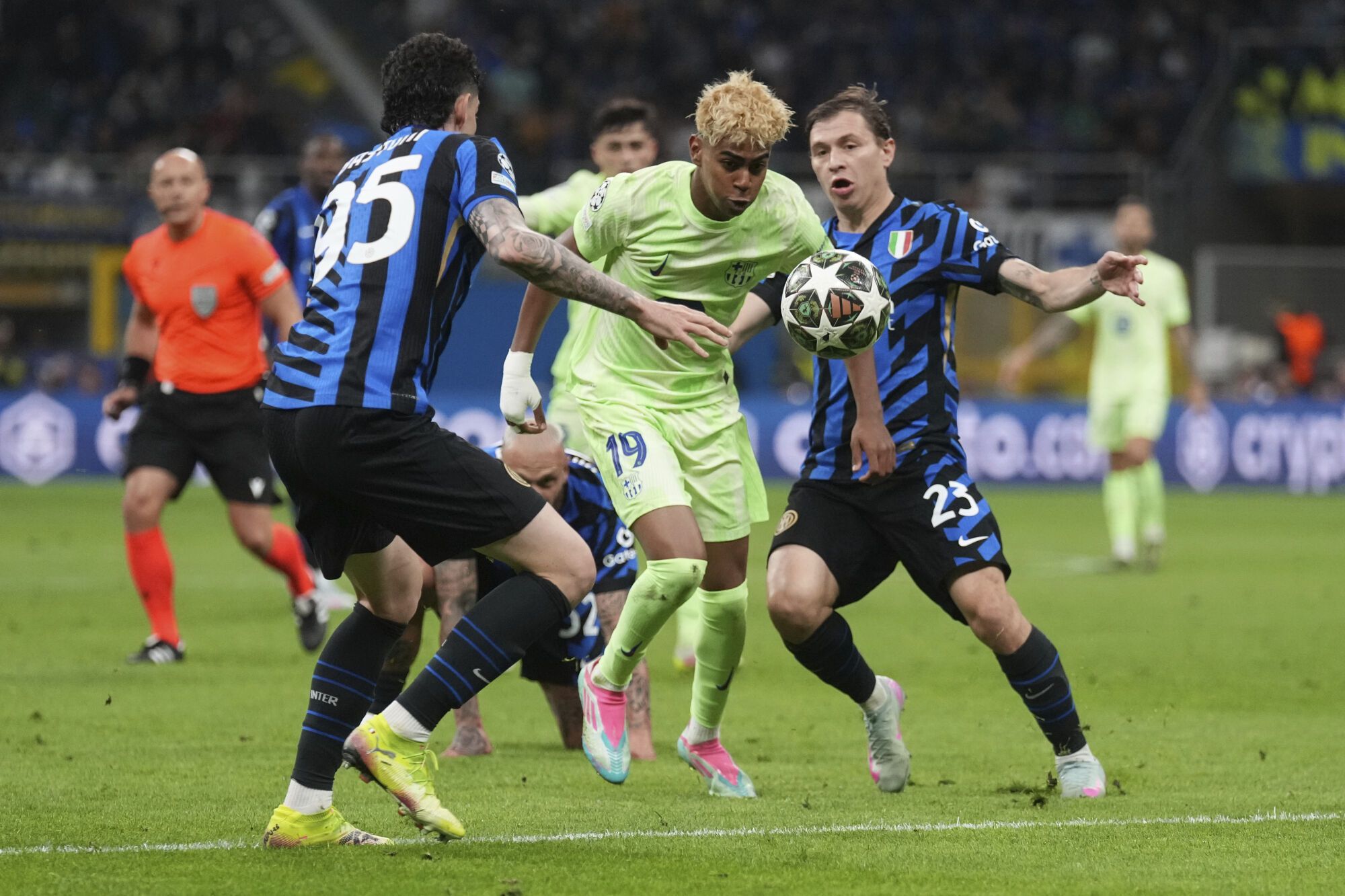 Barcelona's Lamine Yamal in action between IAlessandro Bastoni, left, and Inter Milan's Nicolo Barella during the Champions League semifinal second leg soccer match between Inter Milan and Barcelona at San Siro stadium in Milan , Italy, Tuesday, May 6, 2025. (AP Photo/Antonio Calanni). EDITORIAL USE ONLY / ONLY ITALY AND SPAIN