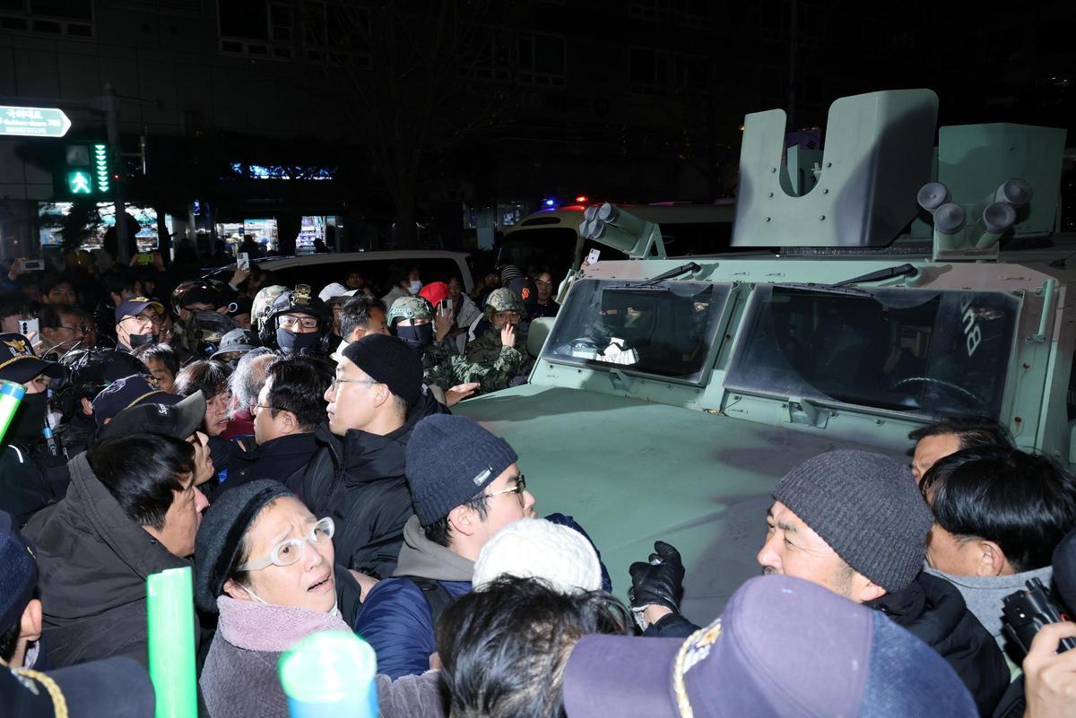 Ciudadanos rodean un vehículo blindado en los alrededores de la Asamblea Nacional de Corea para oponerse a la ley marcial.