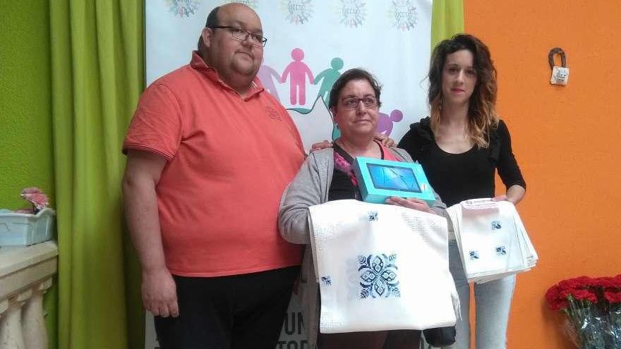 De izquierda a derecha, Ángel García, Cristina Martín y Rocío Esteban, muestran los regalos de la rifa.