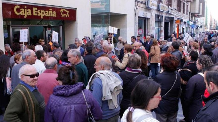 Decenas de afectados protestan ante la sede central de la antigua Caja España.