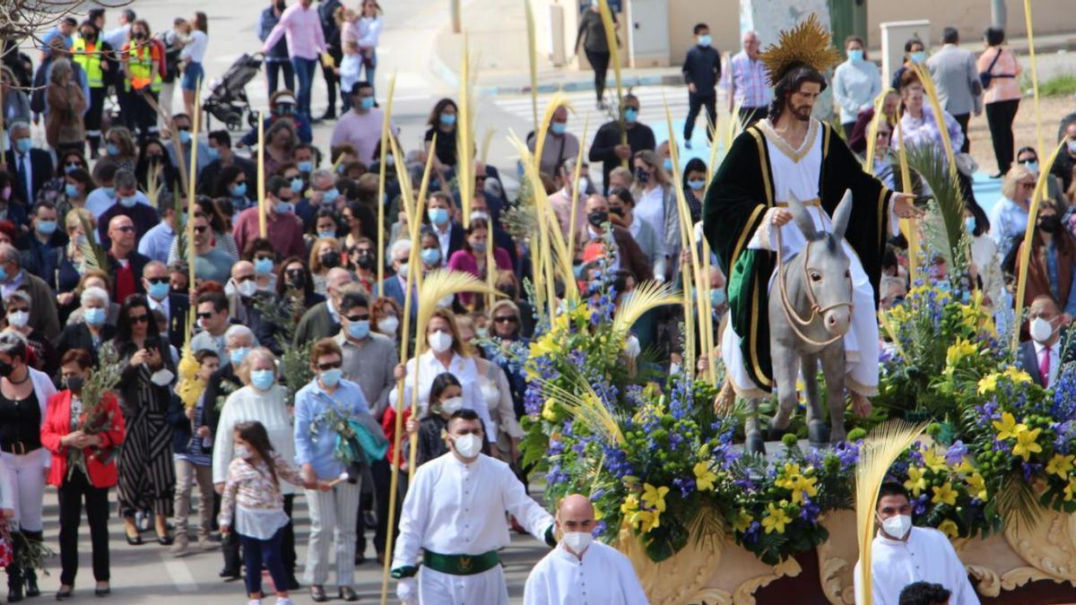 La talla de Ramón Cuenca, seguida por la comitiva oficial y vecinos con palmas y ramos de olivo. | AYTO. SAN PEDRO PINATAR