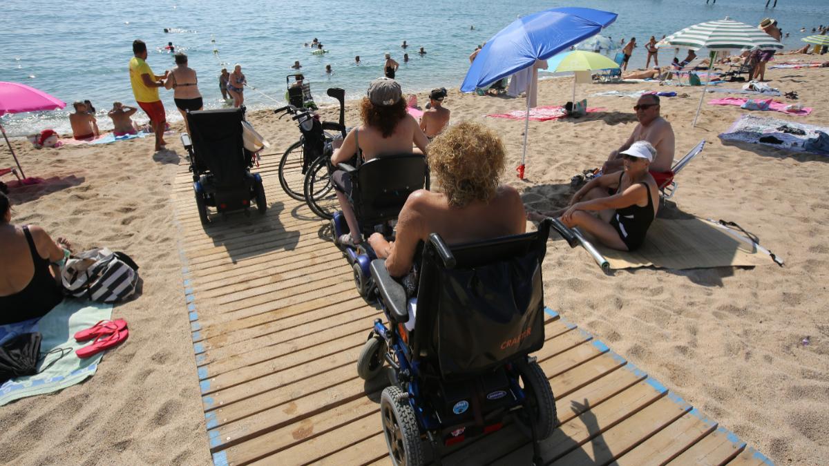 Usuarios de la playa de Badalona aquejados de movilidad reducida para acceder a ella.