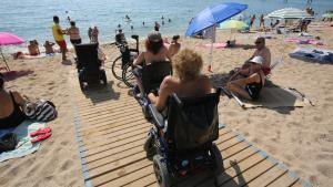 Usuarios de la playa de Badalona aquejados de movilidad reducida para acceder a ella.