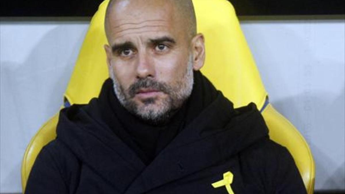 Guardiola, en el banquillo del Manchester City con el lazo amarillo.