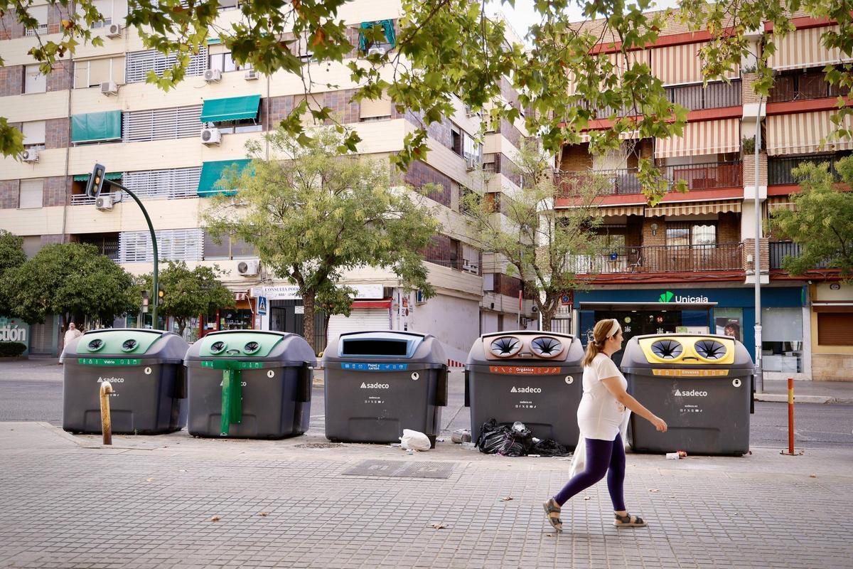 Una mujer pasa por delante de una fila de nuevos contenedores de Sadeco.