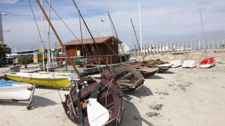 Embarcaciones tradicionales en la playa de Confín, con la sede de Dorna Meca al fondo.  //  Muñiz