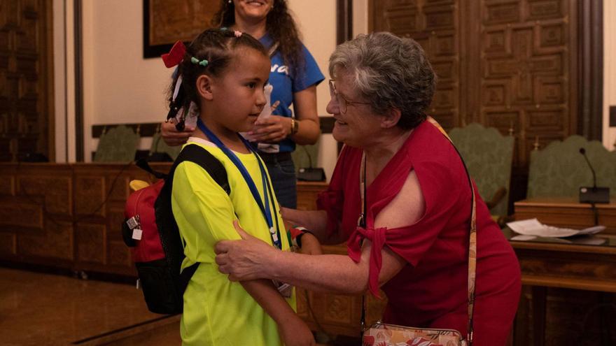 Una niña junto a su madre de acogida zamorana, en la recepción en el Ayuntamiento de Zamora. | Ana Burrieza