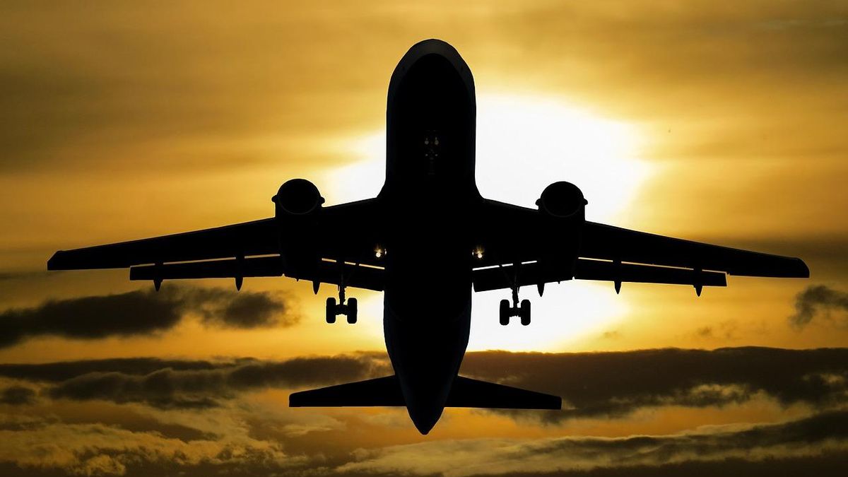 Un avión sobrevuela el cielo durante un atardecer