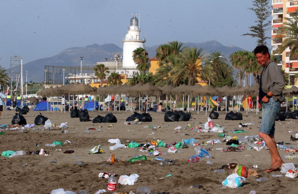 Los operarios de los servicios de limpieza trabajan para dejar la playa en óptimas condiciones tras una larga noche de fiesta en la arena