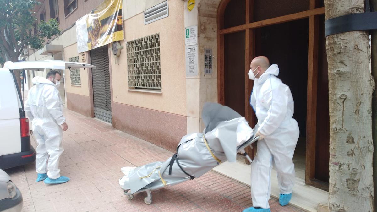 Operaris retiren el cadàver de l’home mort del lloc del crim: la seua pròpia casa.