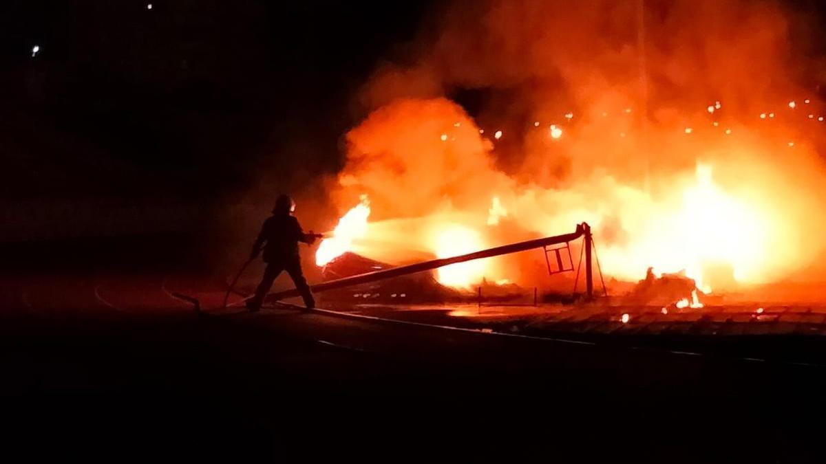 Los bomberos tratan de sofocar las llamas de uno de los incendios.