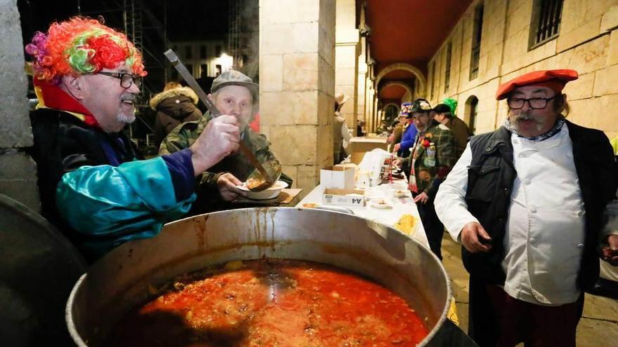 Manuel Ángel González Blanco prepara una de las raciones, entre sus compañeros cofrades.