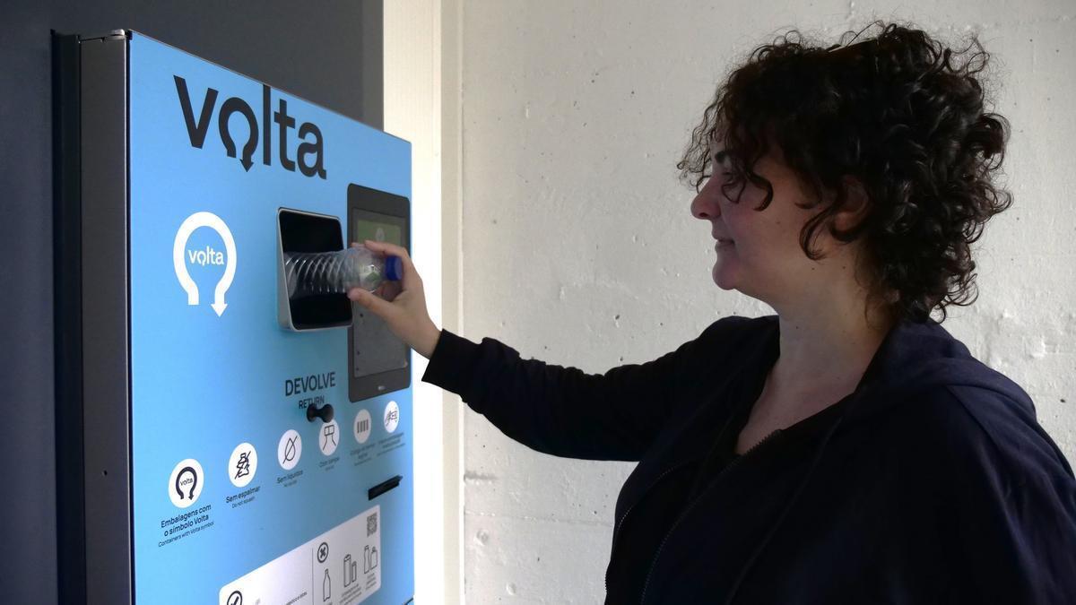 Una consumidora portuguesa devuelve una botella de plástico en una máquina instalada en un supermercado
