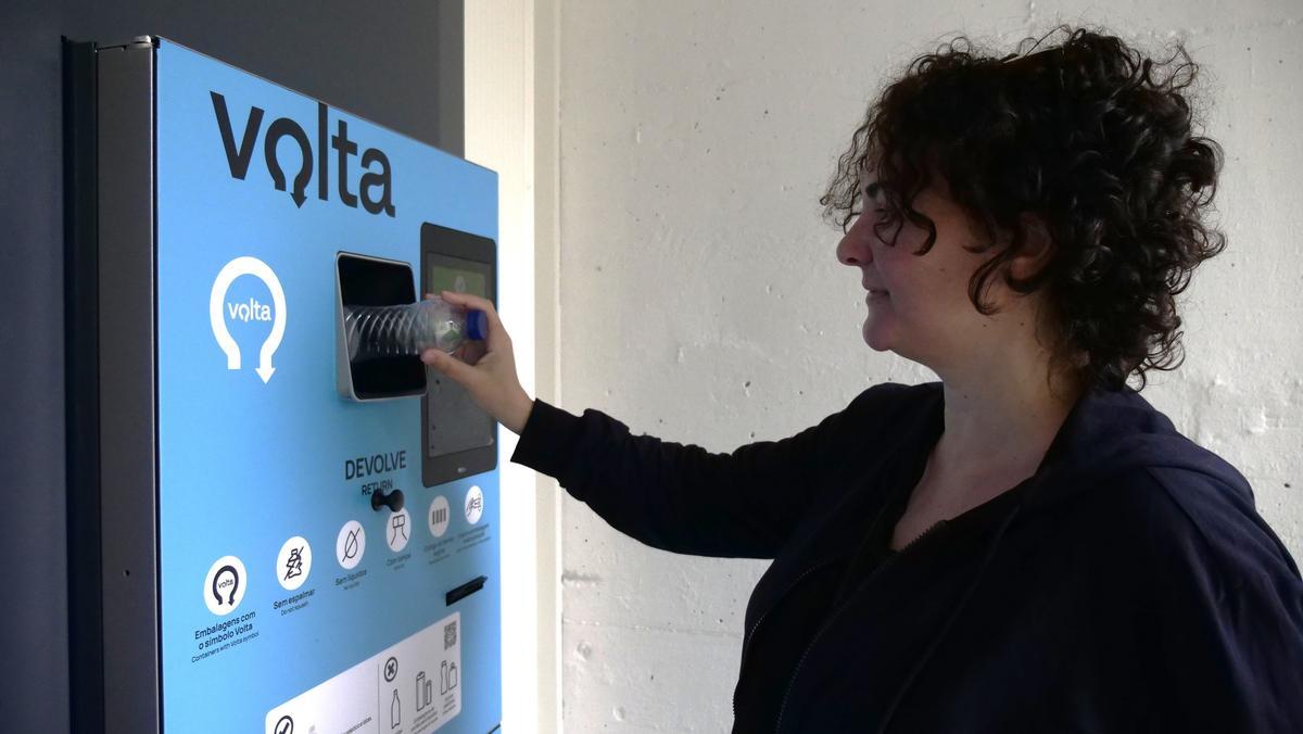 Una consumidora portuguesa devuelve una botella de plástico en una máquina instalada en un supermercado
