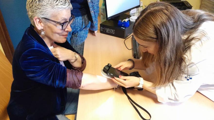 La doctora Natalia Díaz observa con el dermatoscopio la piel del brazo de la consejera Concepción Saavedra.