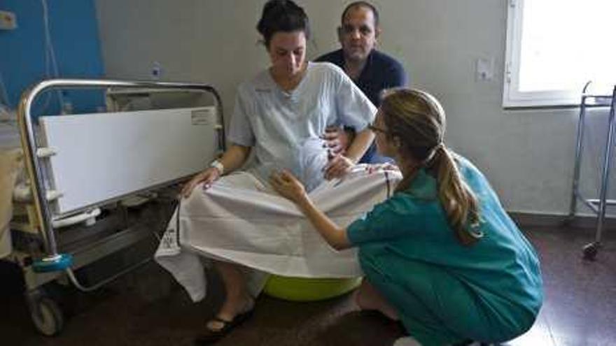 Una matrona atiende a una mujer que está a punto de dar a luz.