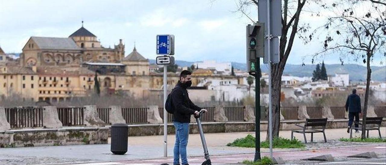 Un joven conduce un patinete eléctrico por el casco histórico de Córdoba.