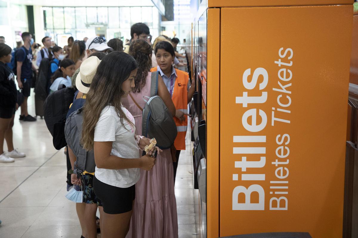 Una joven trata de aclararse con la máquina de venta de billetes de Sants