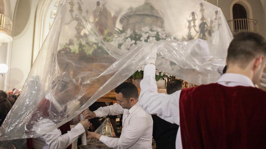 Un paso de Elche cubierto con plásticos el lluvioso Lunes Santo de 2016