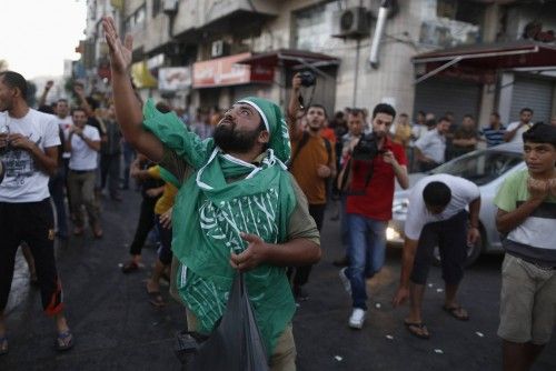 Ciudadanos palestinos celebran en las calles de Gaza el alto el fuego.