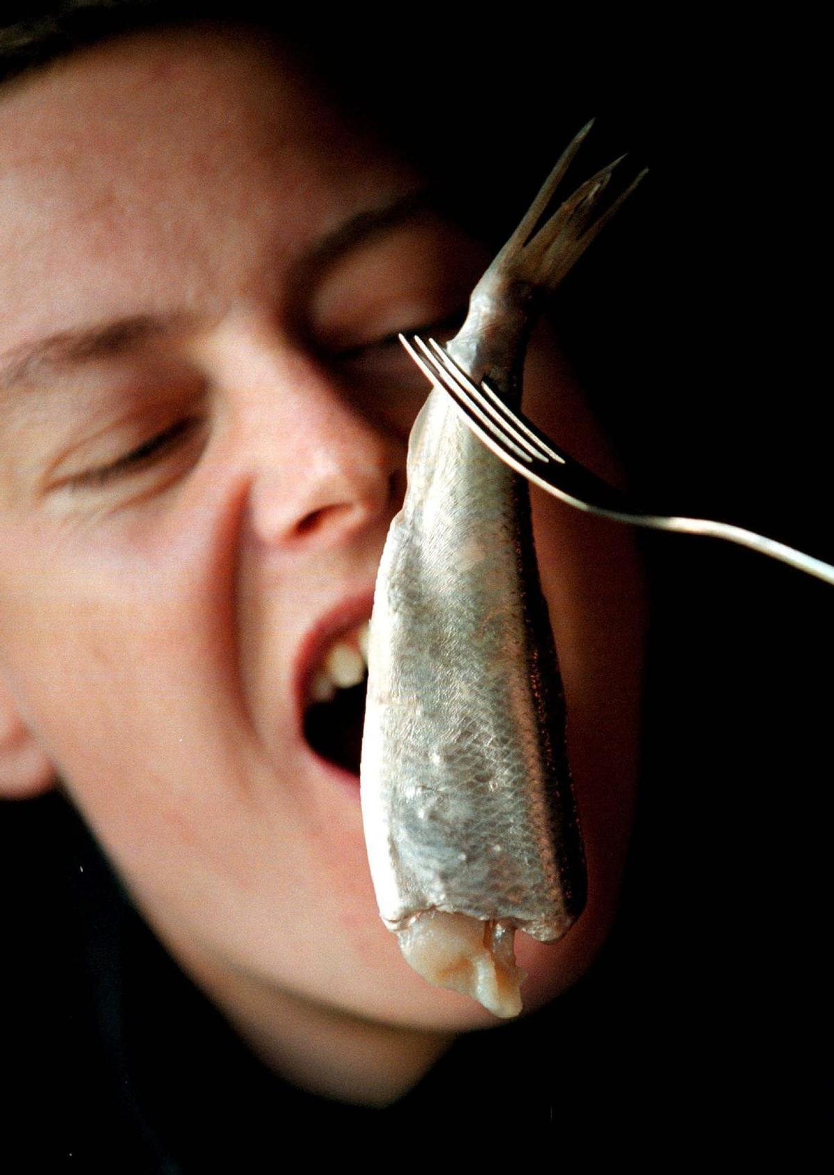 Una mujer, a punto de comerse un pez.