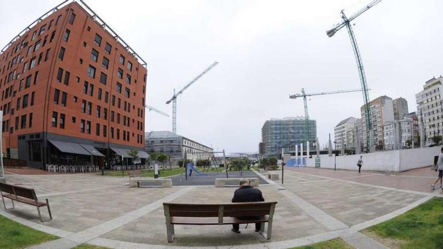 Zona de descanso, área infantil, un bloque de pisos y dos con las obras paradas en la plaza de Tabacos.