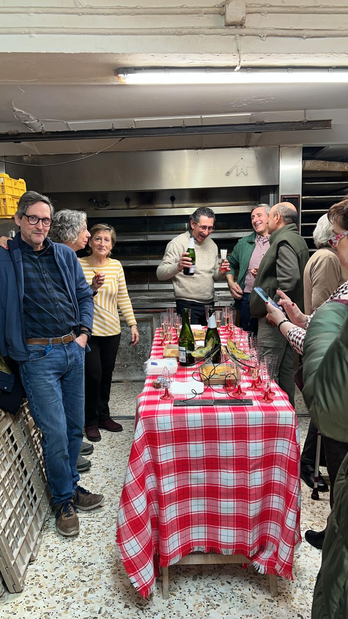 Varios vecinos de Burbáguena reunidos en la Panadería Peribáñez en una fiesta sorpresa en honor a la trayectoria del obrador