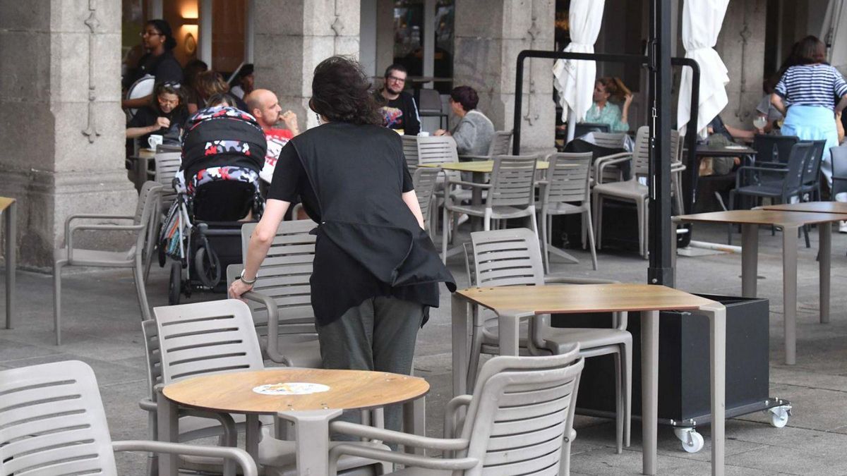 Una camarera instala una terraza en el centro de A Coruña. | Víctor Echave