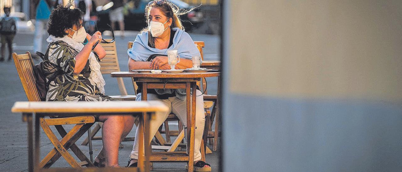 Dos mujeres toman un café en la terraza de un bar de Santa Cruz de Tenerife