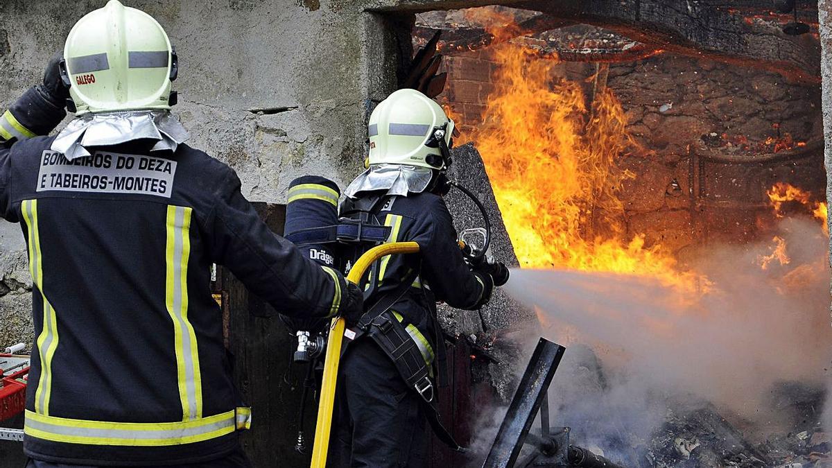 Bomberos de Deza-Tabeirós-Montes, apagando el fuego que arrasó una casa en Cerdedo. |   // BERNABÉ / J.LALÍN