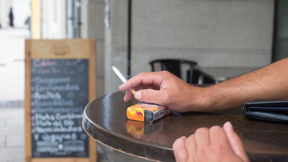 Un hombre fumando en una terraza de un bar en Lugo.