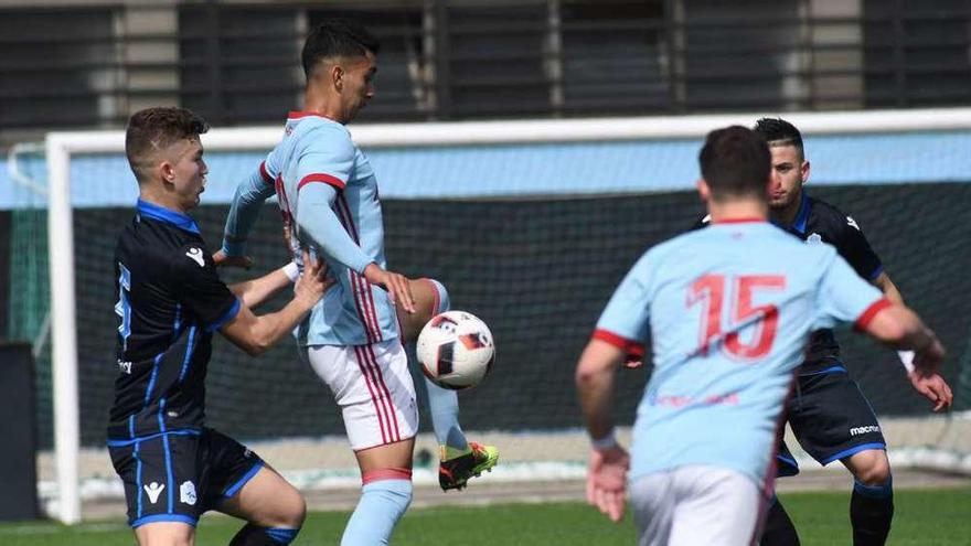 Un jugador del Celta controla el balón ante la presión de un rival en un partido en A Madroa. // E. Álvarez