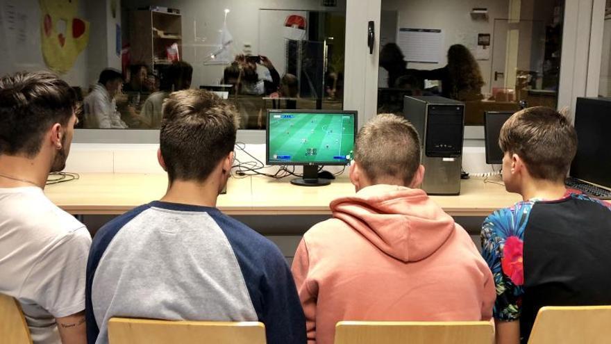 Joves practicant amb la PlayStation el joc del FIFA 19
