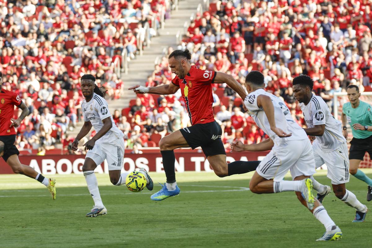 El delantero kosovar del Mallorca Vedat Muriqi (c) ante la defensa del Real Madrid durante el partido de la jornada 30 de LaLiga EA Sports, que disputan el RCD Mallorca y el Real Madrid este sábado, en Son Moix, Palma de Mallorca. EFE/ Cati Cladera. (Mallorca)