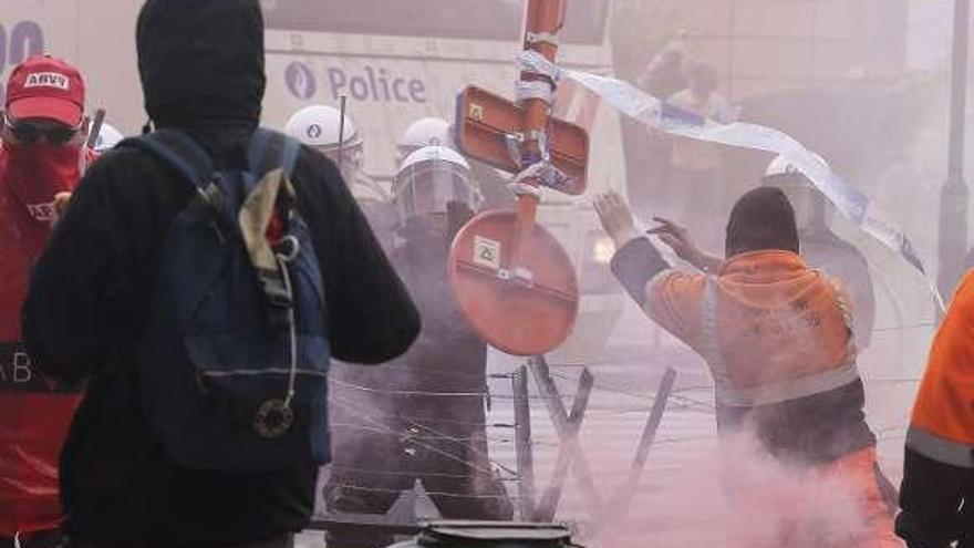 Un manifestante arroja una señal a los policías.  // Efe