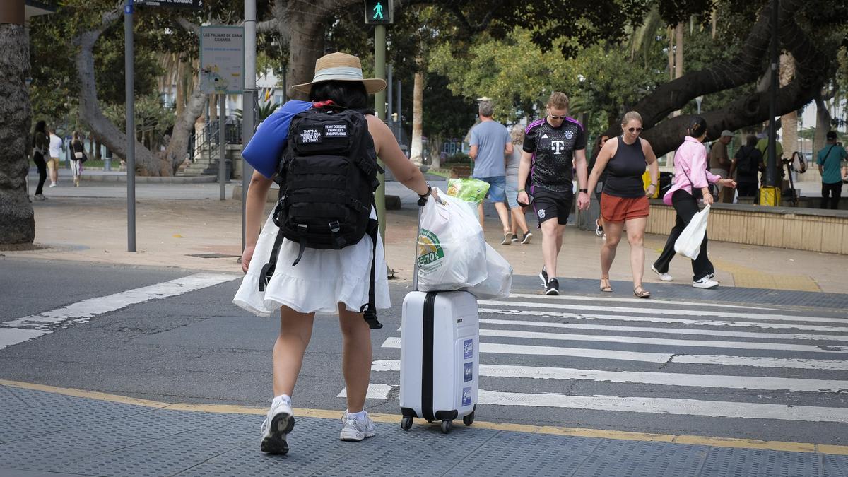Una turista camina con su maleta.