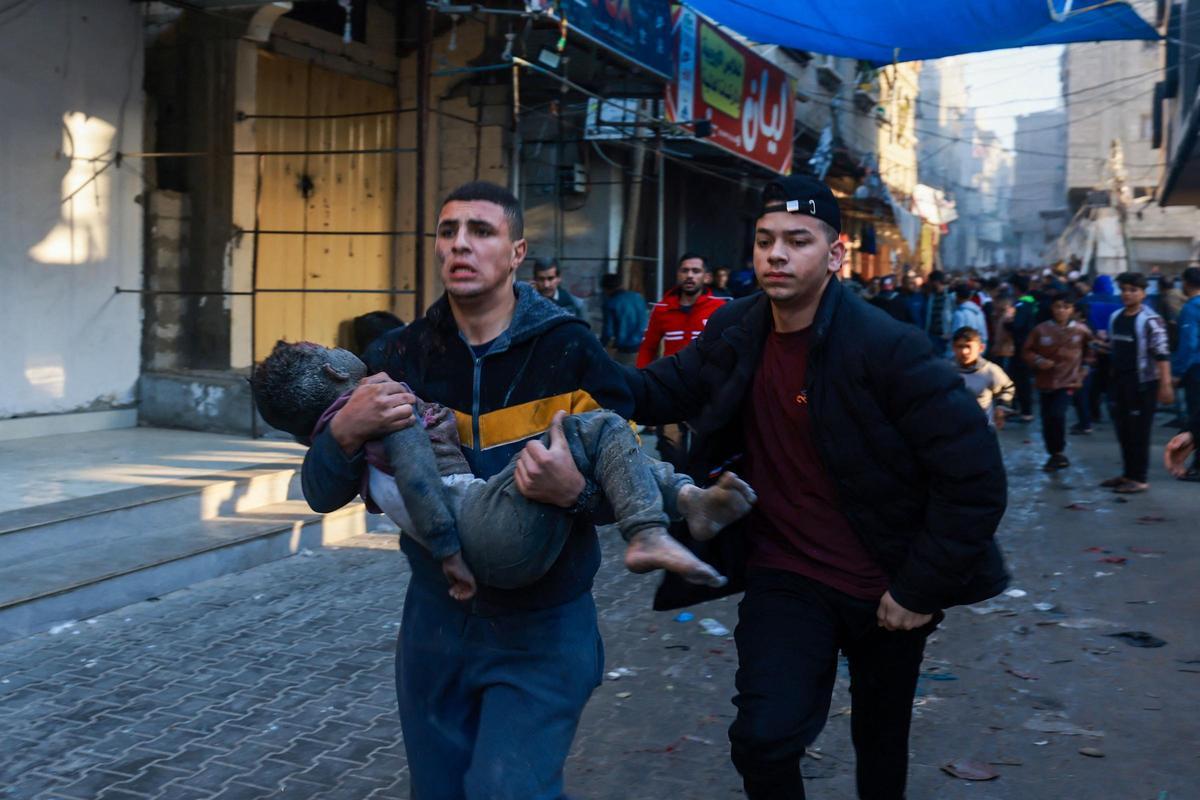 Un palestino carga a un niño herido tras la reanudación de los bombardeos israelíes en Rafah, en el sur de la Franja de Gaza, el 1 de diciembre de 2023, cuando estallaron los combates poco después de la expiración de una tregua de siete días entre Israel y Hamás.