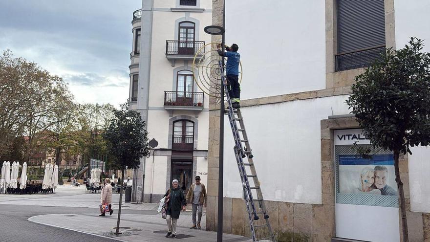 Un operario instala decoración navideña en la calle de Pedro Menéndez. | S. F. / R. S.