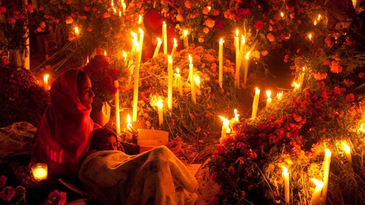 Los cementerios de Oaxaca se iluminan al caer la noche con miles de velas, candelas y lamparillas que arden en torno a las tumbas y los nichos.