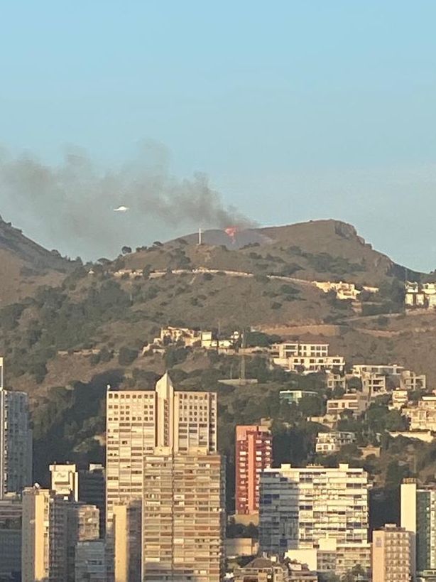 Otra imagen del fuego, donde se observa un helicóptero que participa en las labores de extinción.