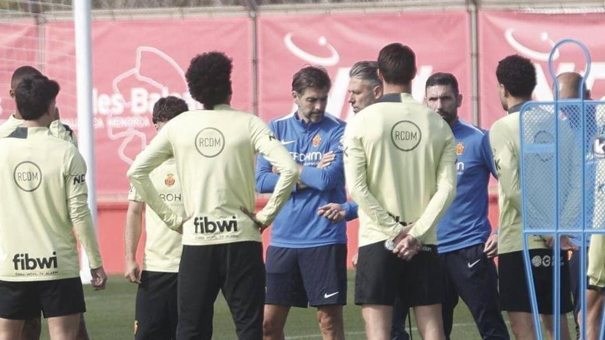 Germán Lux, junto a Martín Demichelis mientras el técnico da una charla a los jugadores.