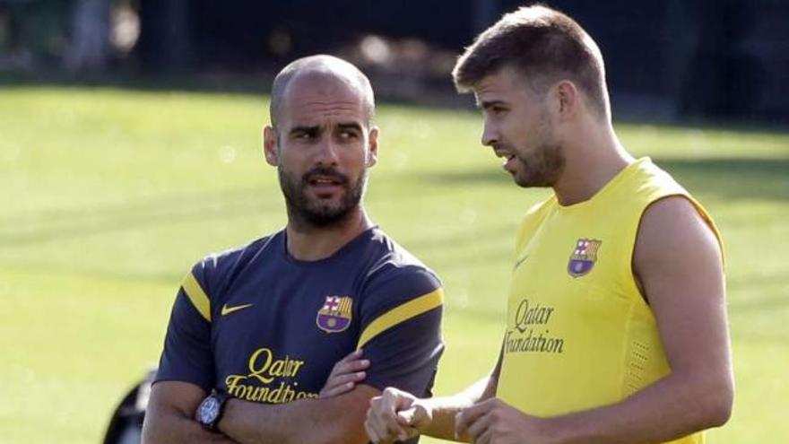 Piqué conversa con Guardiola en un entrenamiento del Barcelona. // Albert Gea