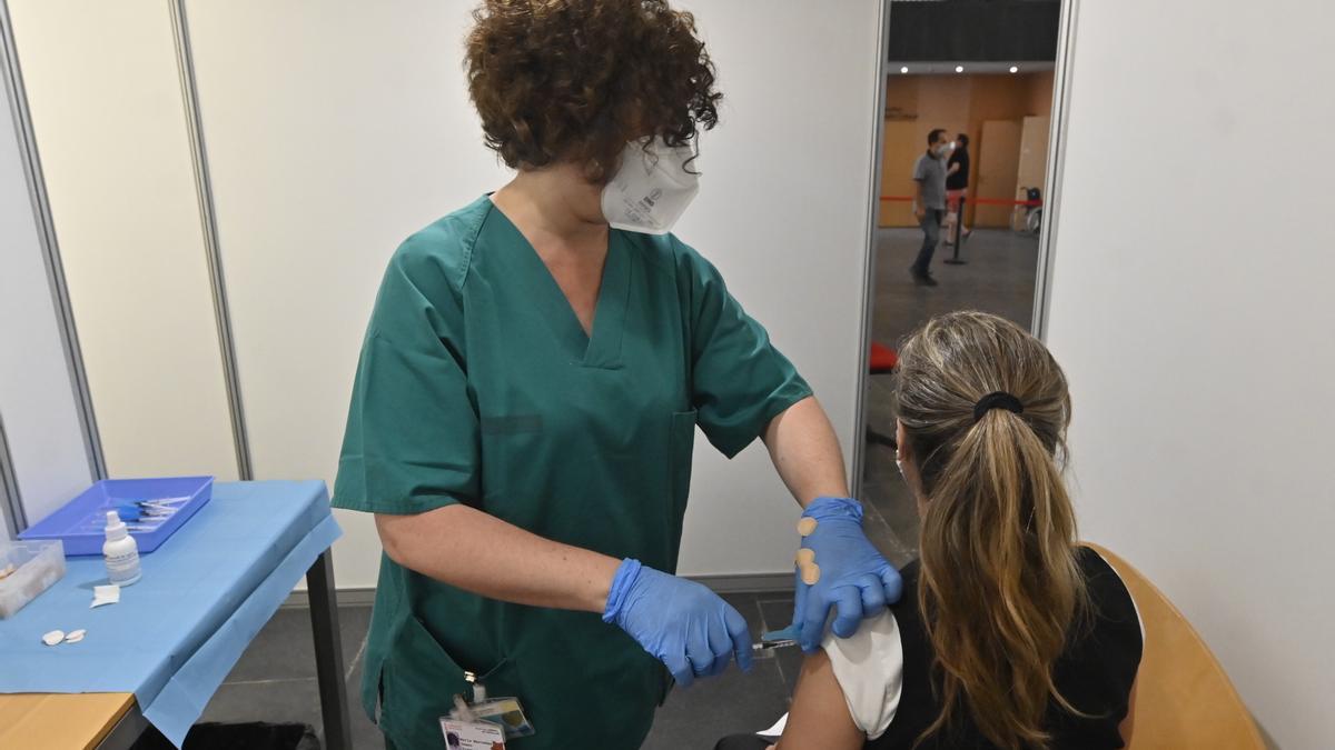 Una enfermera inmuniza a una pacientes en el centro de vacunación masiva del Auditori de Castelló.