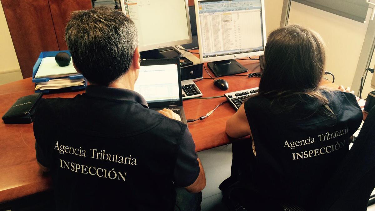 Dos inspectores de la Agencia Tributaria, analizando datos en sus ordenadores.