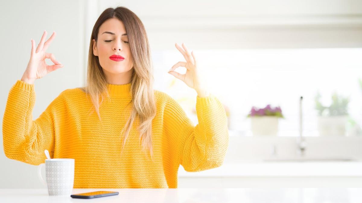 Mujer meditando delante de una taza de café