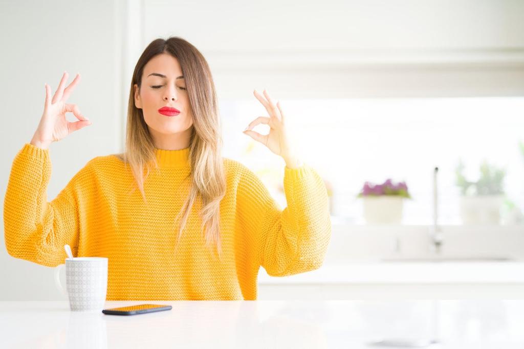 Mujer meditando delante de una taza de café