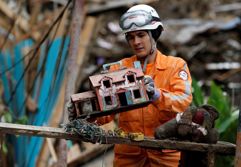 Rescue member finds a toy house in a destroyed ...