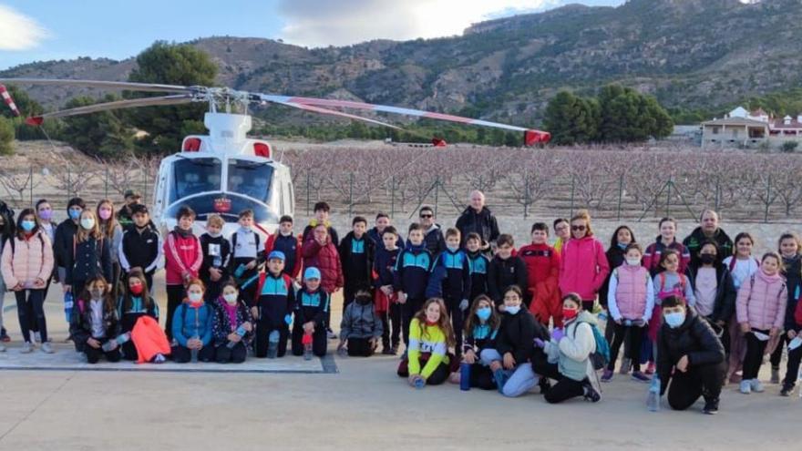 Los alumnos se fotografiaron junto a un helicóptero. A la derecha, en labores de limpieza.